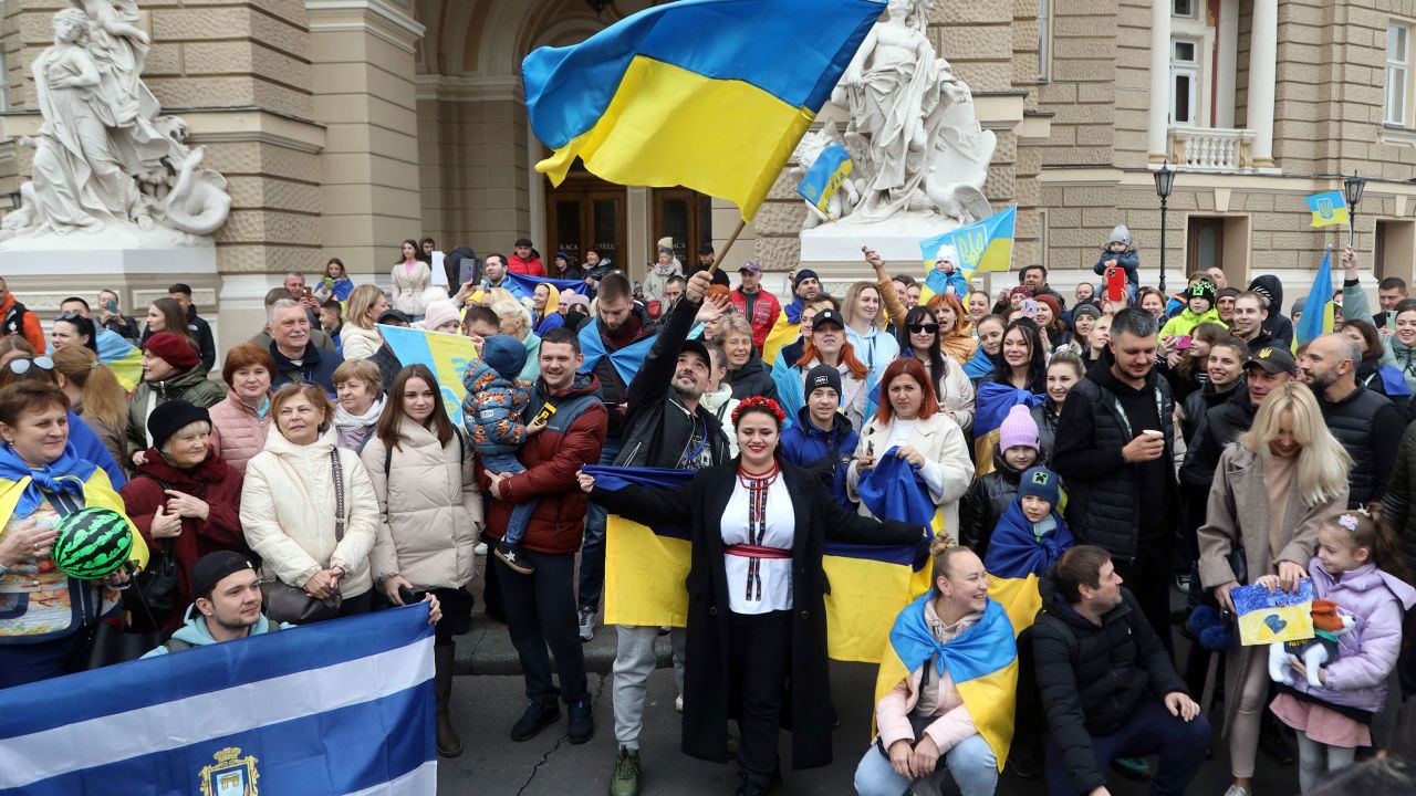 Residents of Kherson temporarily living in Odessa, holding Ukrainian flags, celebrate the liberation of their native town on Saturday.