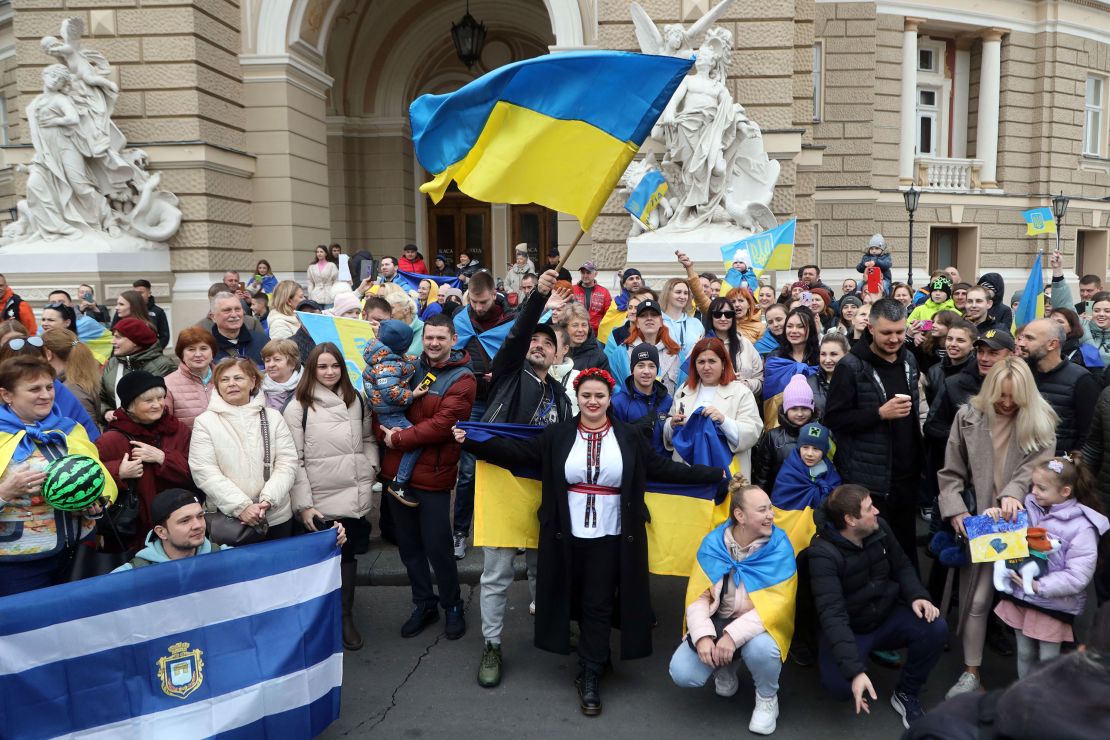Residents of Kherson temporarily living in Odessa, holding Ukrainian flags, celebrate the liberation of their native town on Saturday.