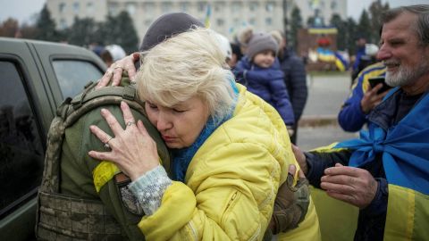 A local resident hugs a Ukrainian military officer as people celebrate Russia's withdrawal from the city of Kherson in central Kherson, Ukraine, on November 12, 2022.