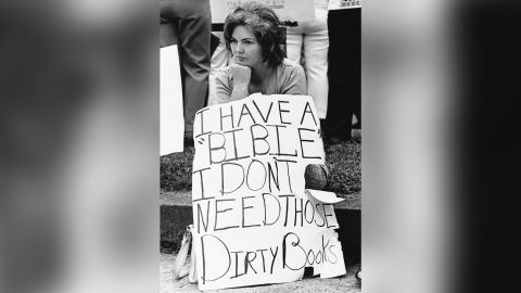 Woman protesting "those dirty books" sits stoically on a curb in Charleston, West Virginia, in 1974. Schools were firebombed and school buses fired at in the controversy. 