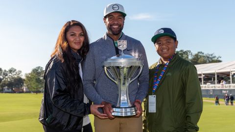 Finau poses with the Houston Open trophy next to his family.