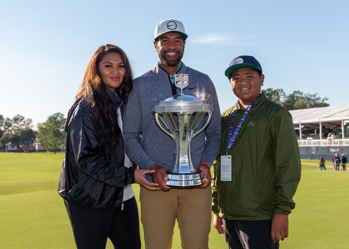 Finau poses with the Houston Open trophy alongside his family.
