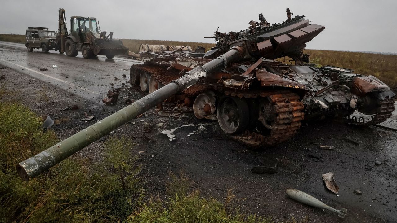A destroyed Russian tank is seen as Ukrainian serviceman rides a tractor and tows a Russian military vehicle near the village of Dolyna, Ukraine, on September 23, 2022.