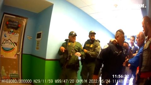 Pargas, a la derecha, con una camisa azul, ayuda a detener a Rubén Ruiz, un oficial de policía escolar cuya esposa, Eva Mireles, llamó desde su salón de clases para decir que se estaba muriendo. 