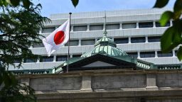 The Japanese national flag flutters in the wind on part of the Bank of Japan (BoJ) headquarters buildings in Tokyo on September 14, 2022. - Japan's central bank on September 14 conducted an operation often seen as a precursor to currency intervention, local media said, as the yen continues to crater against a strengthening dollar. (Photo by Richard A. Brooks / AFP) (Photo by RICHARD A. BROOKS/AFP via Getty Images)