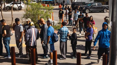 Groups of migrants wait outside the Migrant Resource Center to receive food from the San Antonio Catholic Charities on September 19 in San Antonio.