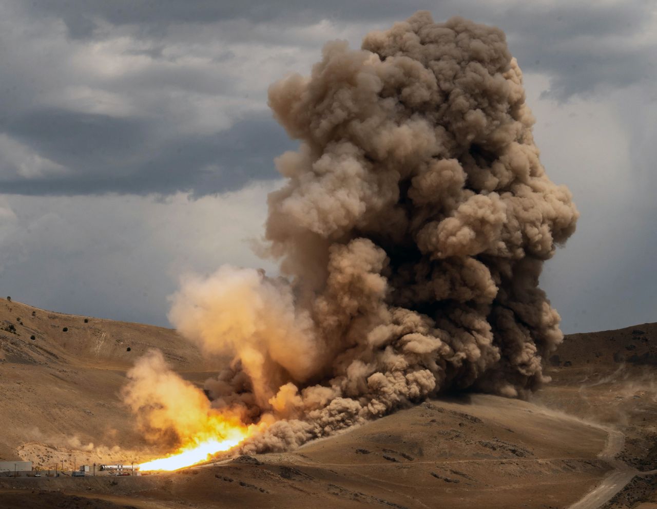 A solid rocket booster motor fires up on July 21 at Northrop Grumman's test facility in Promontory, Utah. The booster motor, positioned horizontally for the ground test, fired for a little over two minutes and produced 3.6 million pounds of thrust, according to NASA.