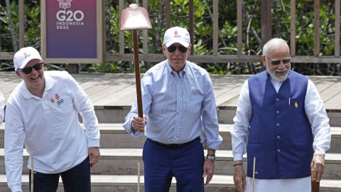Standing with Australian Prime Minister Anthony Albanese, left, and Indian Prime Minister Narendra Modi, right, President Joe Biden raises his garden hoe during a tree planting event at the Taman Hutan Raya Ngurah Rai Mangrove Forest, on the sidelines of the G20 summit meeting on Wednesday, Nov. 16, 2022.
