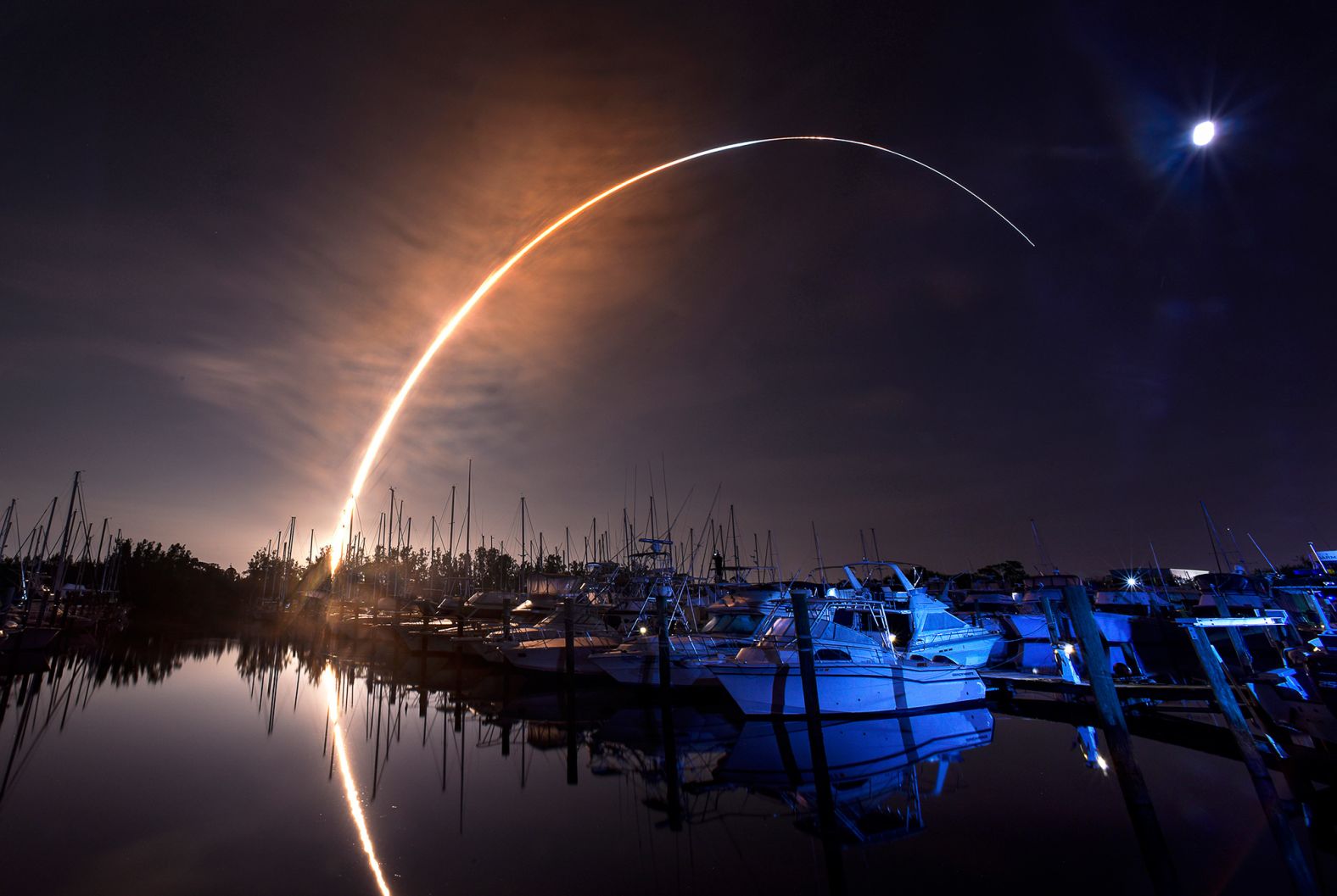 The Artemis I rocket lifts off through the night sky, seen in this long-exposure photograph taken from Merritt Island, Florida.