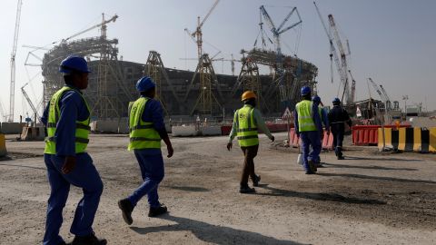 Workers walk to the Lusail Stadium -- one of the 2022 Qatar World Cup stadiums -- in Lusail on December 20, 2019. 
