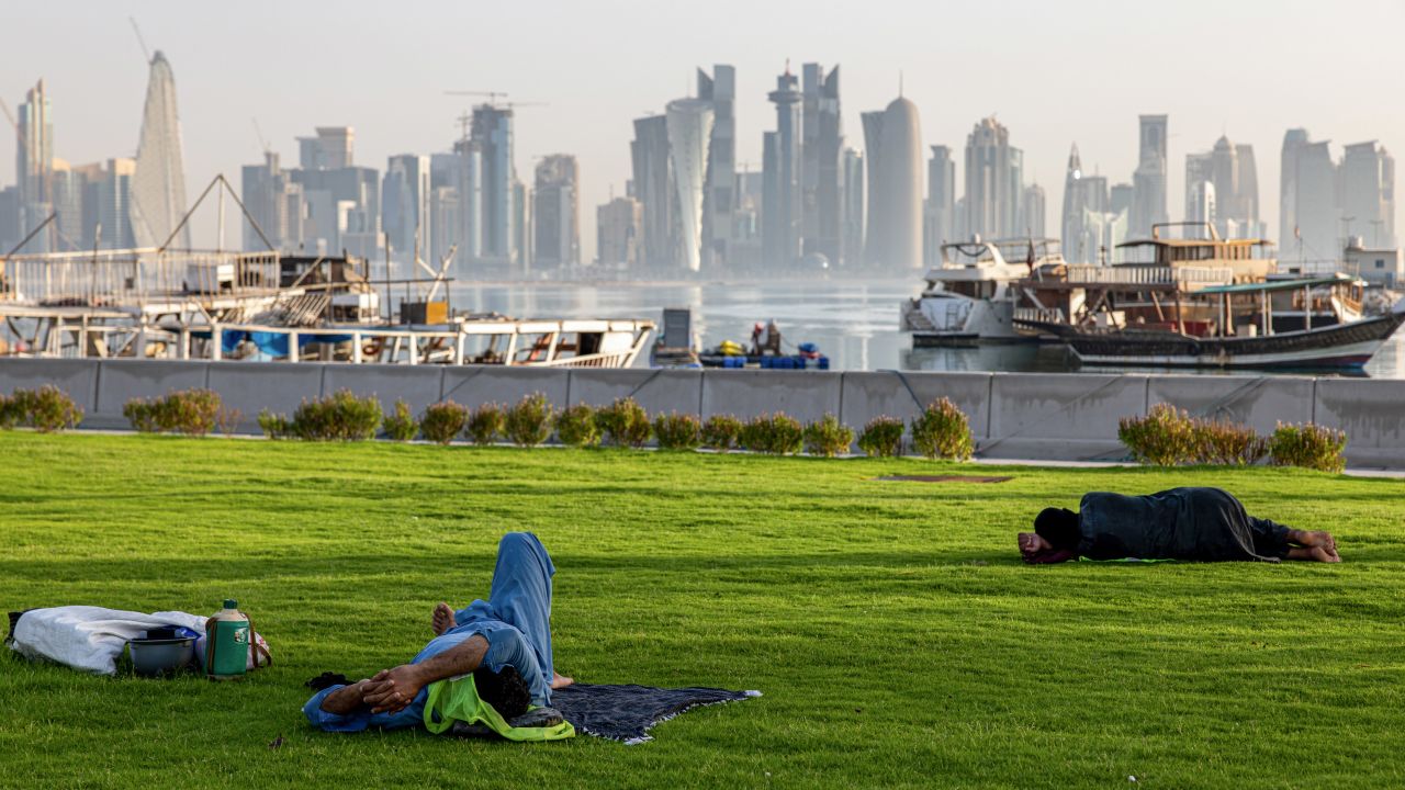 Laborers rest in green space along the corniche in Doha, Qatar, on June 23. 