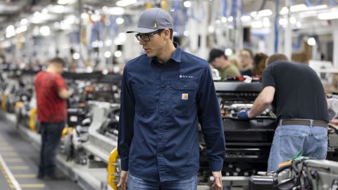 Scaringe watches as workers build chassis at Rivian's electric vehicle plant in Normal, Illinois.