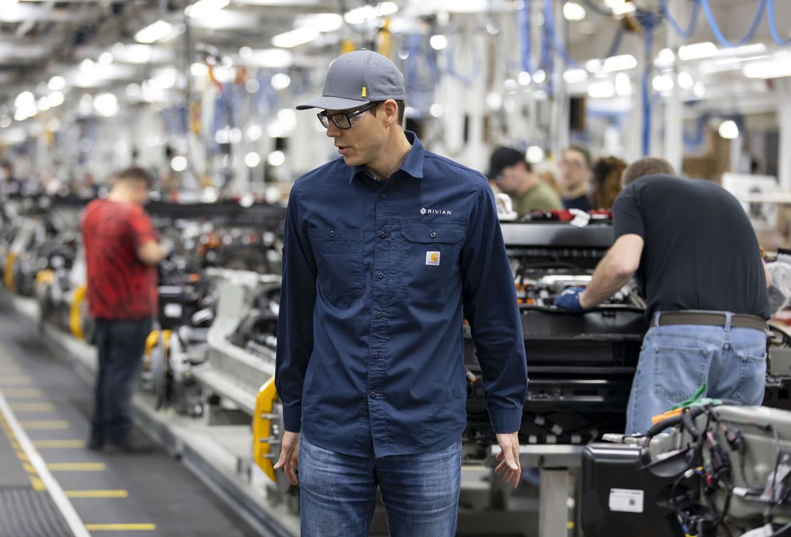 Scaringe watches as workers build chassis at Rivian's electric vehicle plant in Normal, Illinois.