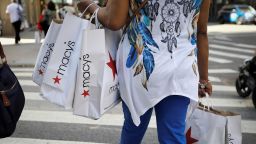 A woman carries shopping bags from Macy's department store in midtown Manhattan in New York City, on July 9, 2020. 
