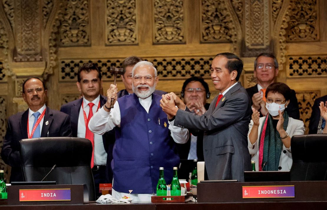 India's Prime Minister Narendra Modi and Indonesia's President Joko Widodo hold hands during the handover ceremony at the G20 leaders' summit, in Nusa Dua, Bali, Indonesia, November 16, 2022. 