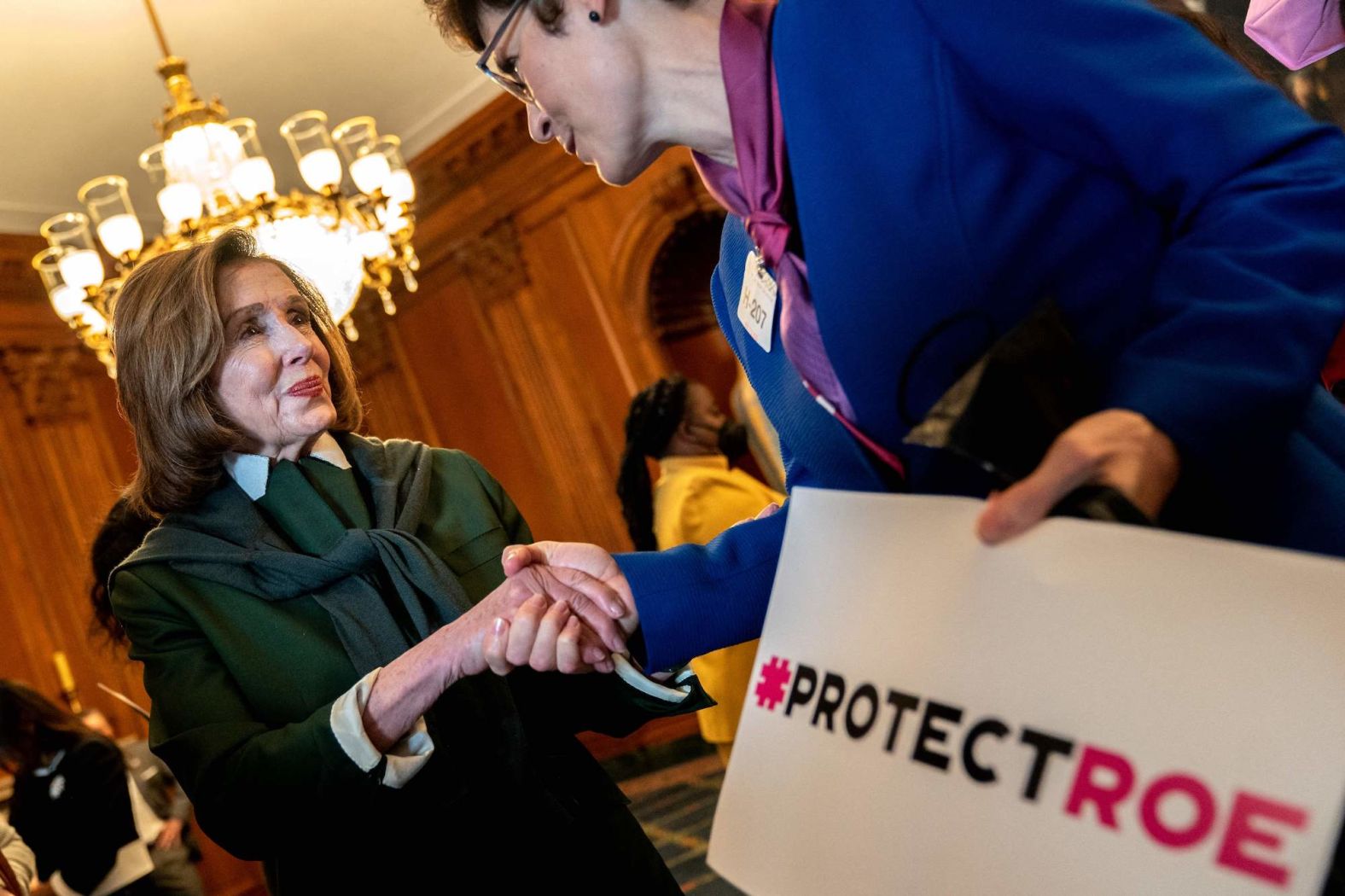 Pelosi shakes hands with a pro-choice advocate prior to a press conference about the leaked Supreme Court draft decision on Roe v. Wade in May 2022.