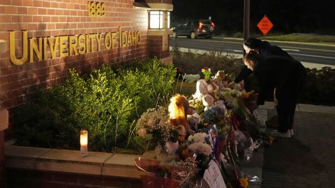 Two men lay flowers at a growing memorial in front of the University of Idaho campus entrance sign on Wednesday.