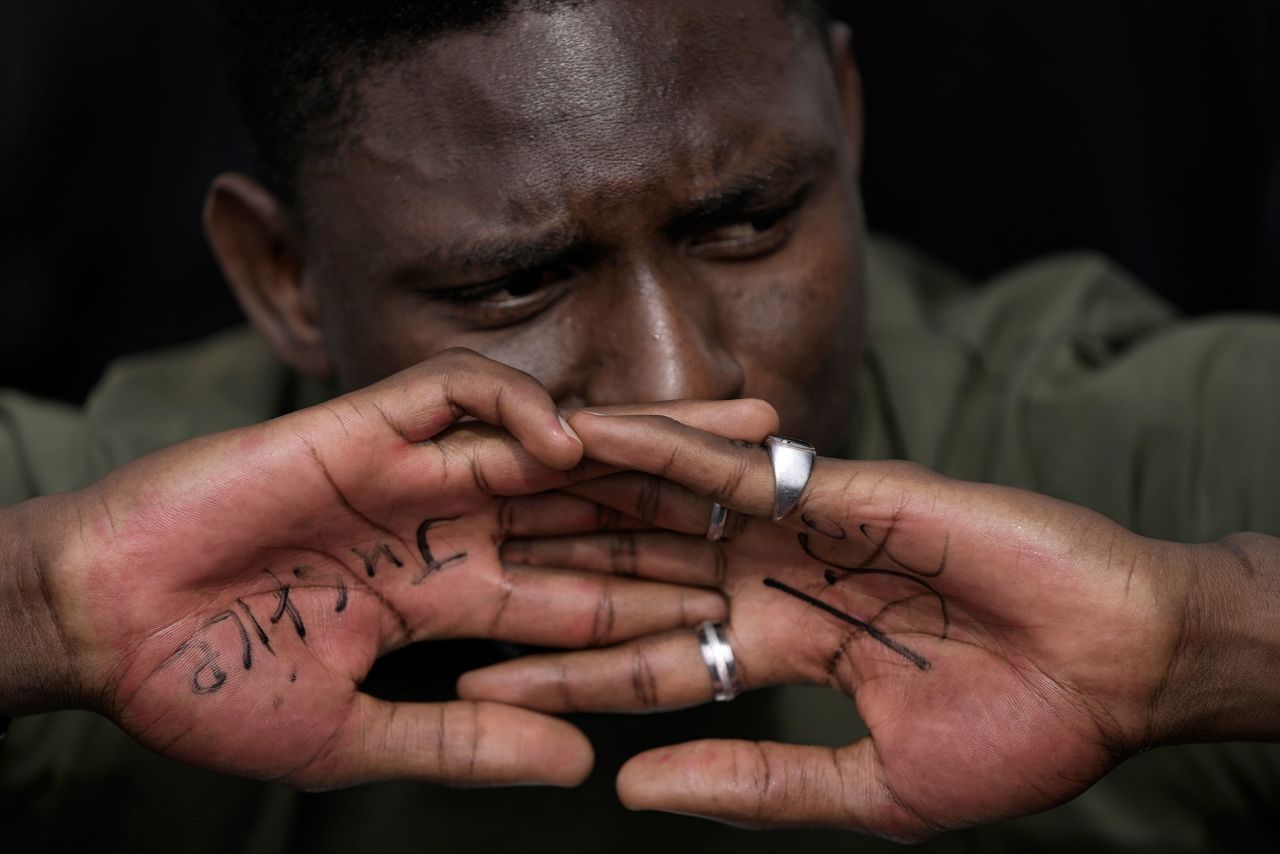 A man displays his hands that say "justice" and "1.5" while taking part in a protest at the <a href="https://www.cnn.com/2022/11/06/world/cop27-egypt-what-to-watch-climate" target="_blank">COP27 climate summit</a> in Sharm el-Sheikh, Egypt, on Wednesday, November 16. A flood of recent reports have made clear leaders are running out of time to implement the vast energy overhaul needed to keep the temperature from exceeding 1.5 degrees Celsius, the threshold scientists have warned the planet must stay under.