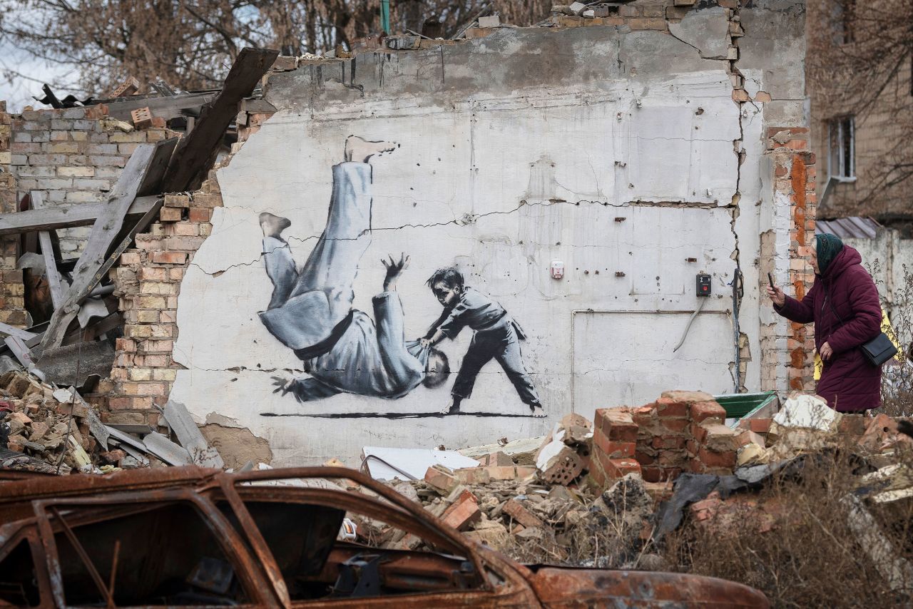 A woman takes a picture of artwork that was created by British street artist Banksy on a destroyed building in Borodianka, Ukraine, on Sunday, November 13. Banksy confirmed that he did <a href="https://www.cnn.com/style/article/banksy-ukraine-murals/index.html" target="_blank">a series of murals</a> in the region.