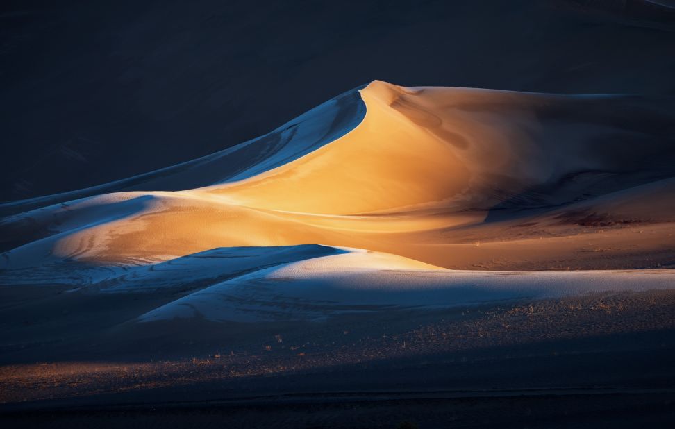 The prize for "Photographer of the Year" went to American Brent Clark, who submitted impressive shots of American wilderness, from a desert canyon in Utah to an alpine lake in Wyoming. In this image, titled "Amor Fati," light breaks through an out-of-frame mountain pass to illuminate one shapely section of sand dunes in California.