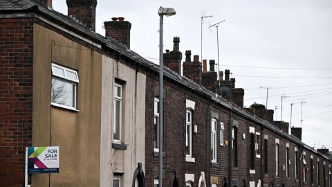 An estate agent's 'For Sale' board is pictured on a house at the end of a row of terraced houses in northern England on November 2, 2022. 