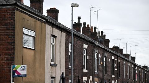 An estate agent's 'for sale' board is pictured on a house at the end of a row of terraced homes in northern England on November 2, 2022.