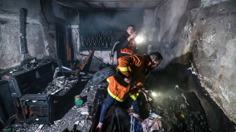 Palestinian firefighters put out a fire in a building destroyed by fire in the Jabalia refugee camp in Gaza on November 17.