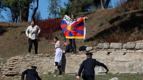 A protester holds a Tibetan flag during the Olympic flame lighting ceremony for the Beijing 2022 Winter Olympics 