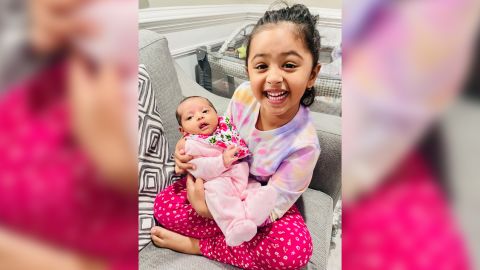 Aavya Pokharel holds her baby sister Ayra after the infant returned from her RSV-related hospitalization.