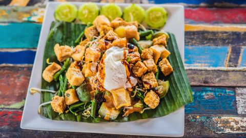 A classic gado gado is served with chopped vegetables, an egg and sometimes, slices of tofu or tempeh. It is often dressed with roasted peanut sauce.