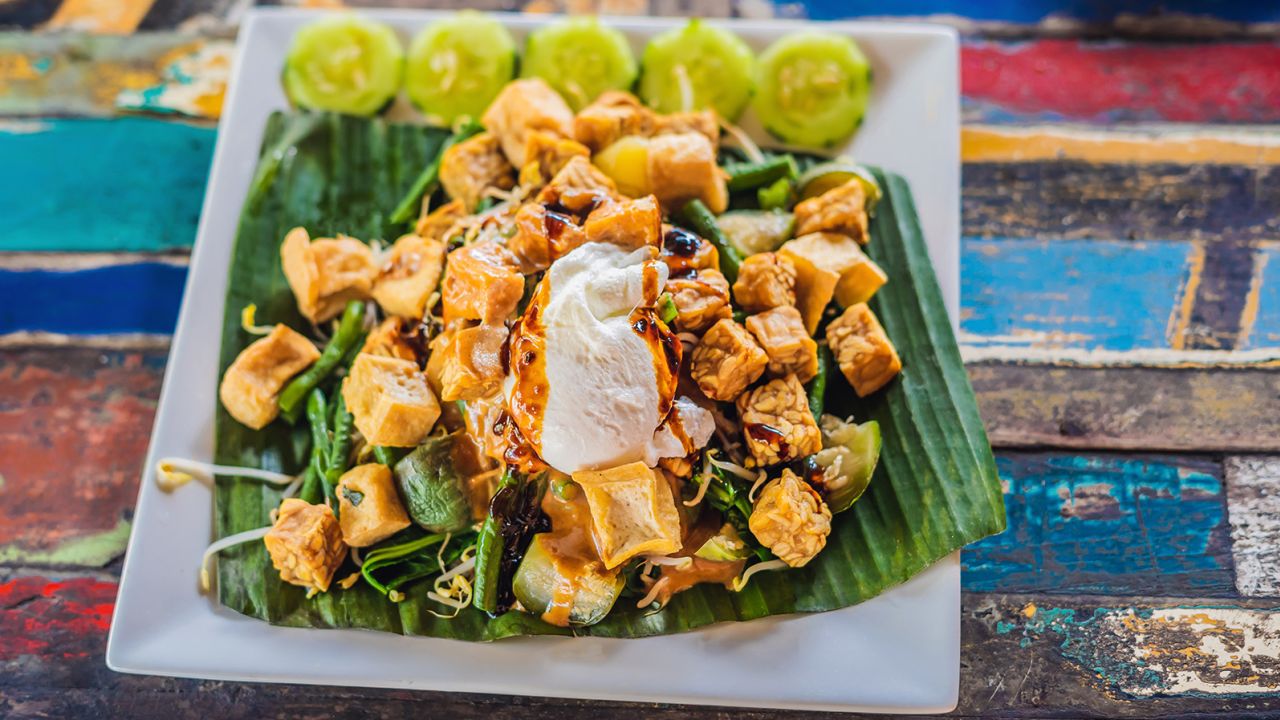 A classic gado gado is served with chopped vegetables, an egg and sometimes, slices of tofu or tempeh. It is often dressed with roasted peanut sauce.