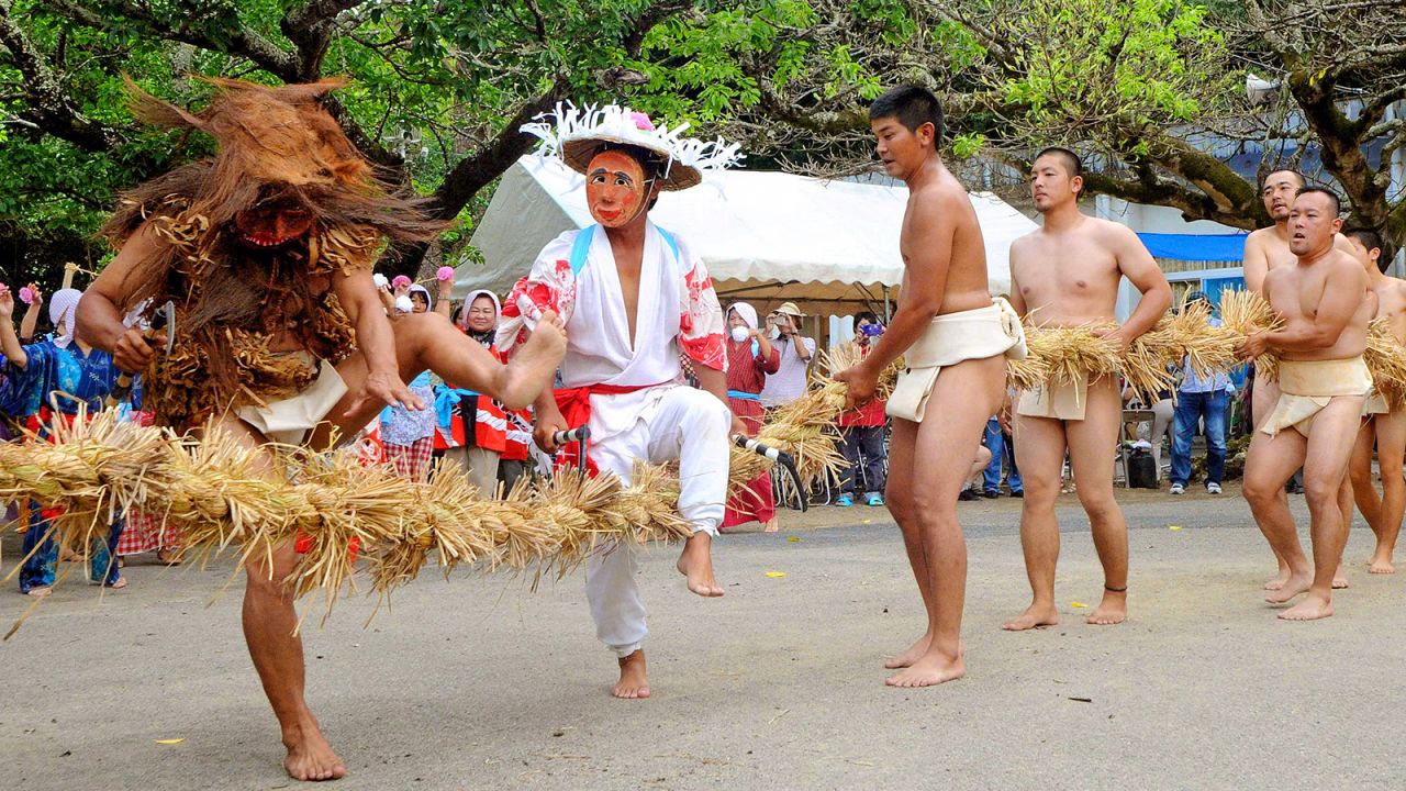 <strong>Good Harvest Festival:</strong> A man tries to cut the rope during a "Tsunakiri" ritual as a part of Amami Oshima's Good Harvest Festival.  