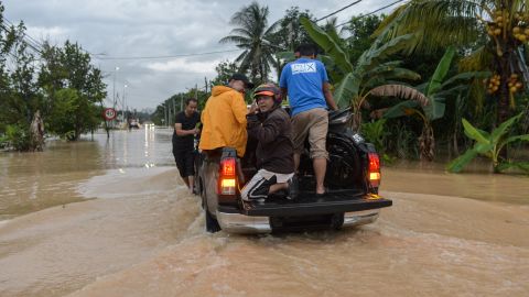 Menschen retten am 10. November 2022 ein Motorrad in einer überfluteten Straße in Klang, Malaysia.