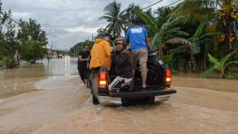 People rescue a motorcycle in a flooded street in Klang, Malaysia on November 10, 2022.