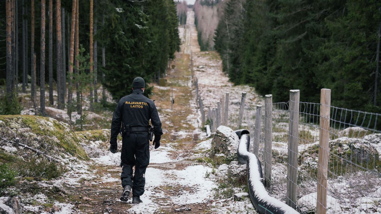 Senior border guard officer Juho Pellinen walks along a fence marking the boundary area between Finland and Russia near the border crossing of Pelkola, in Imatra, Finland on November 18, 2022. 