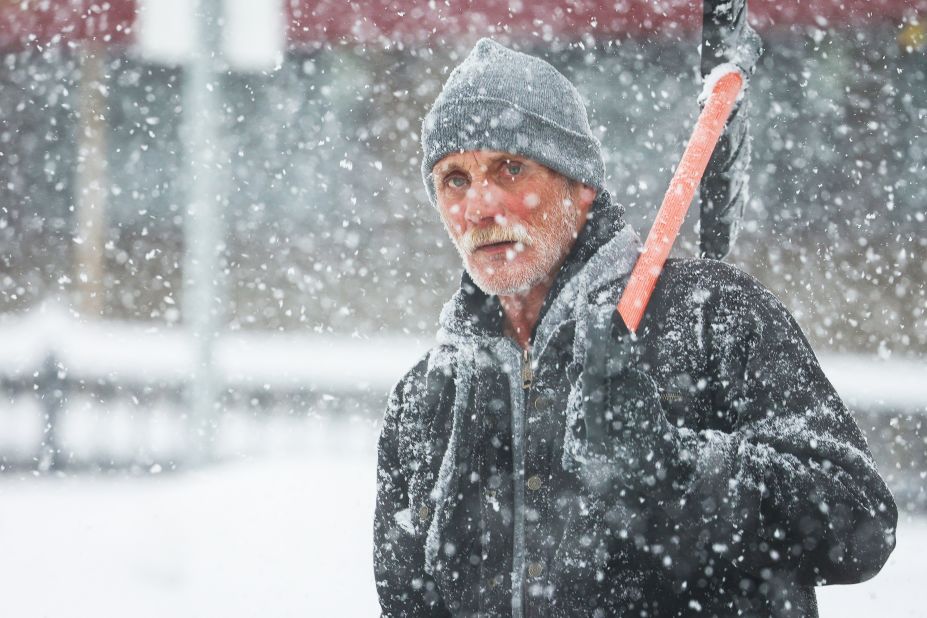 A man walks through the snow with a shovel on Friday.