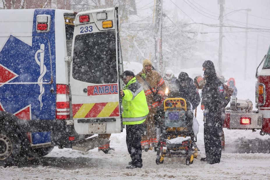 Emergency crews transport an ill patient amidst the snowstorm on Friday.