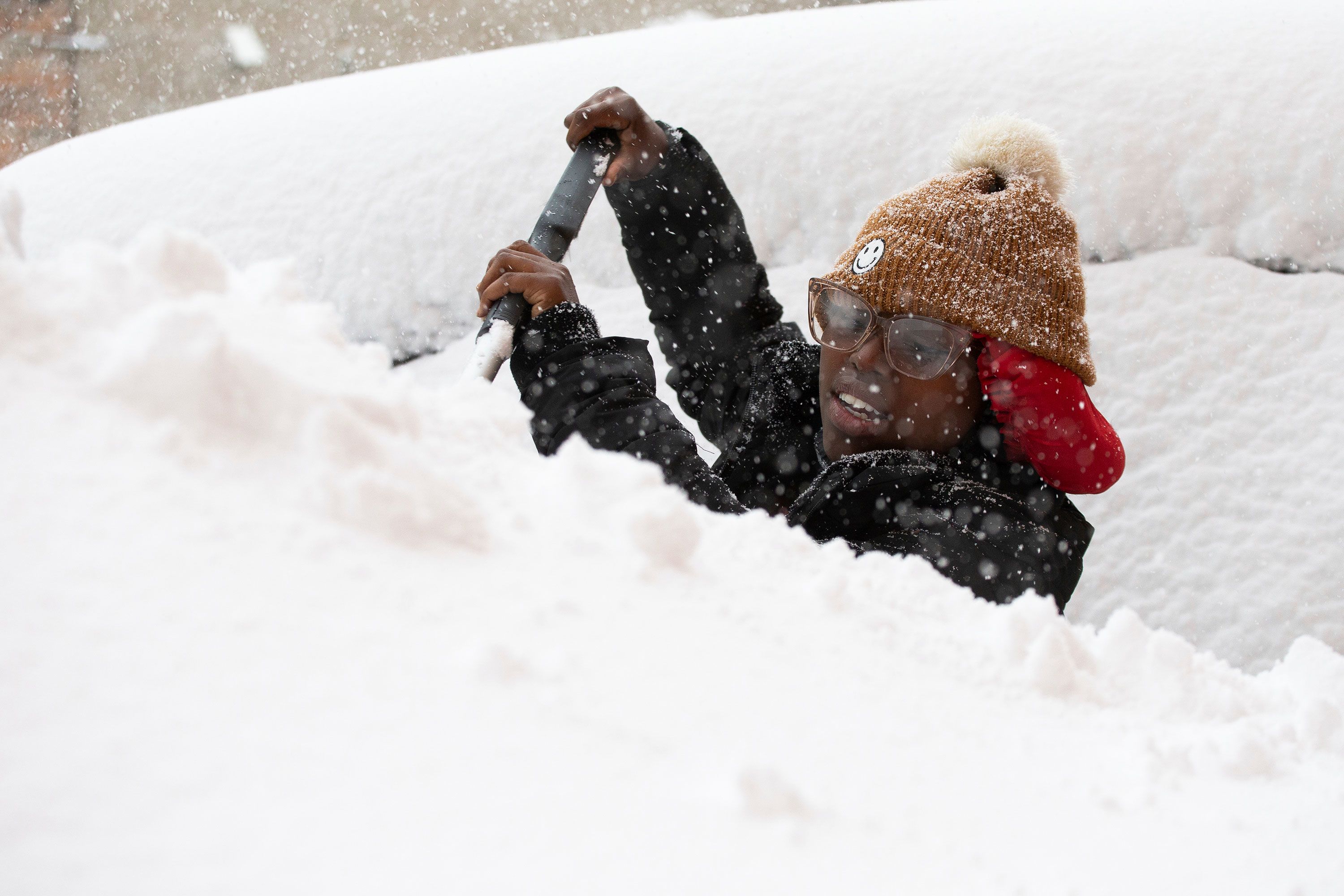 Zaria Black clears snow from her car on Friday.