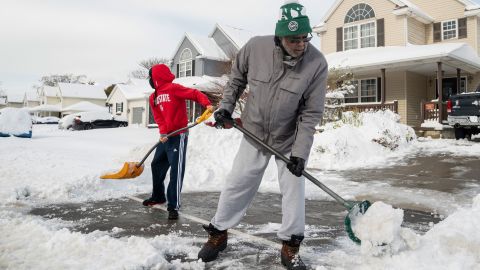 Christopher Middlebrooks and his son Mitchell Middlebrooks work to clear their driveway Friday in Buffalo.
