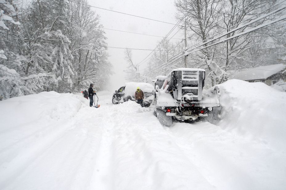 People help dig out a plow from heavy snow in Hamburg, New York, on Friday. 