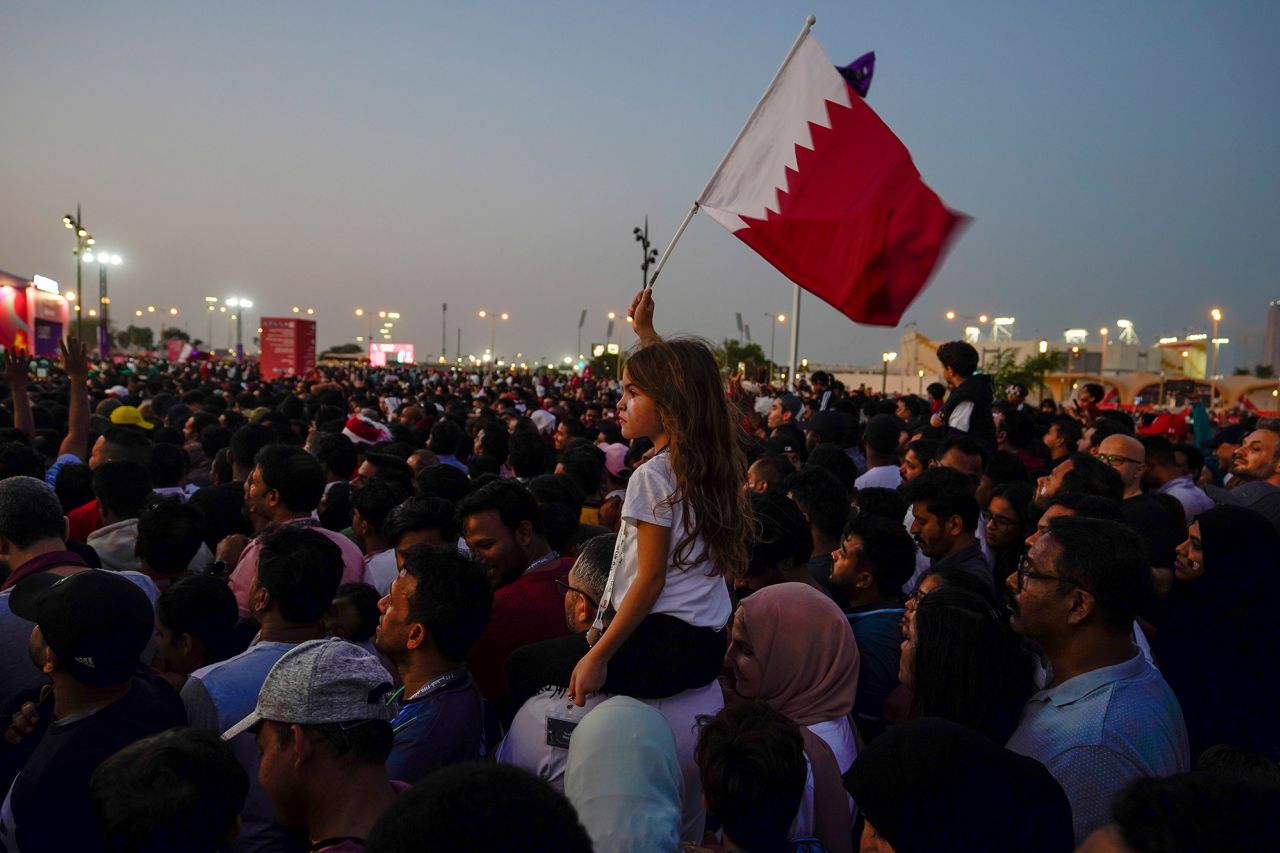 A girl waves a Qatari flag at a fan zone in Doha.