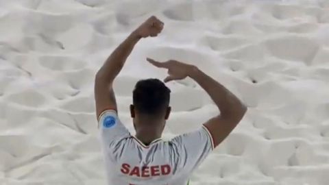 Saeed Piramoon imitates cutting his hair during a match.