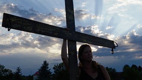 A woman holds a cross during a vigil for victims of the Century 16 movie theatre shooting in Aurora.