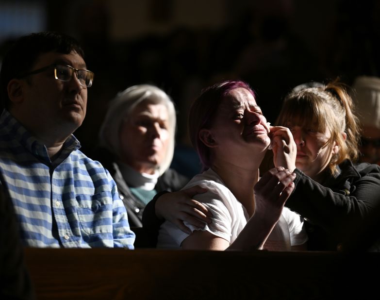 Jessi Hazelward wipes a tear from her friend Amanda Grueschow's face during a vigil in Colorado Springs on Sunday.