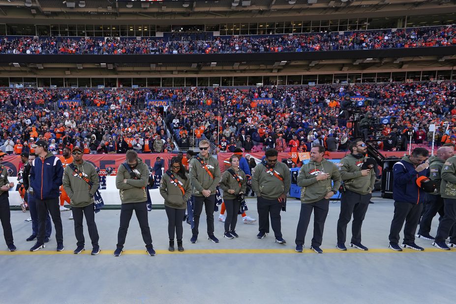 Denver Broncos staff members and fans observe a moment of silence Sunday for the shooting victims.