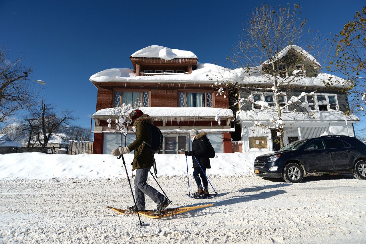 People snowshoe through snow covered streets on Sunday in Buffalo, New York. 