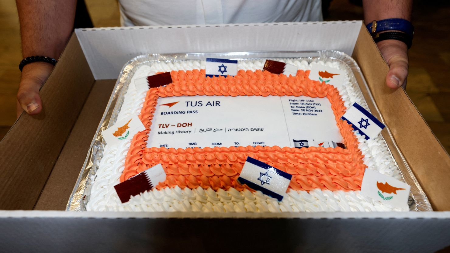 A man holds a cake decorated as a boarding pass, marking the first direct commercial flight between Israel and Qatar for the 2022 FIFA World Cup Qatar, at Ben Gurion International Airport, near Tel Aviv, Israel on November 20.