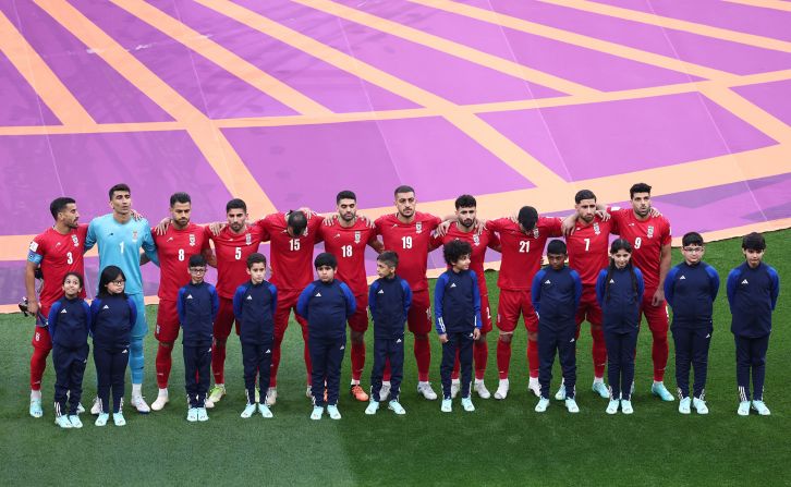 Iranian players line up during the national anthems before the match. <a href="index.php?page=&url=https%3A%2F%2Fwww.cnn.com%2Fsport%2Flive-news%2Fworld-cup-11-21-22%2Fh_50f93bd8ea9d8fd0dccb42479a5b070e" target="_blank">They did not sing</a> during their anthem.