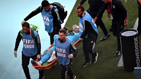 Iran's goalkeeper Alireza Beiranvand leaves the pitch on a stretcher after he was injured in a crash on heads with Iran's defender #19 Majid Hosseini during the game against England.