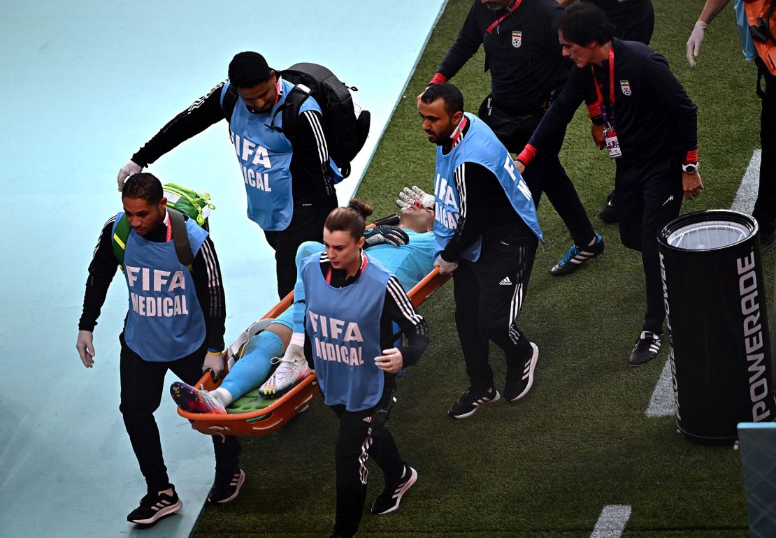 Iran's goalkeeper Alireza Beiranvand leaves the pitch on a stretcher after he was injured in a crash on heads with Iran's defender #19 Majid Hosseini during the game against England.